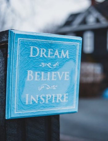 Square light blue signboard with inscription placed on pillar on suburban district in gloomy day